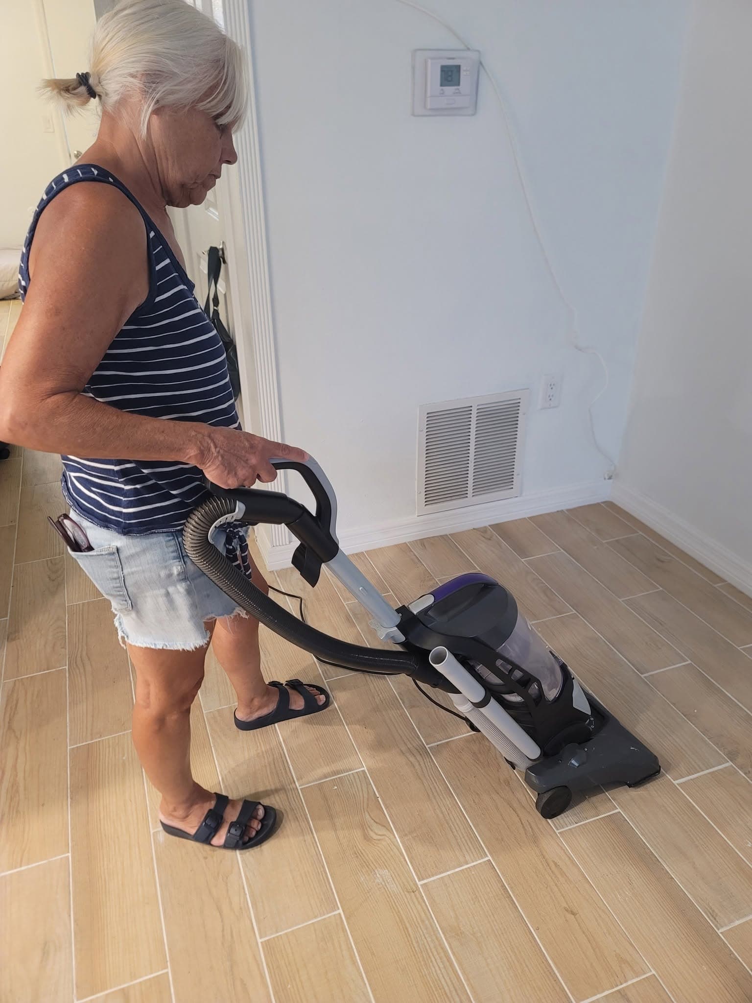 Vacuuming a tile floor in a client's home